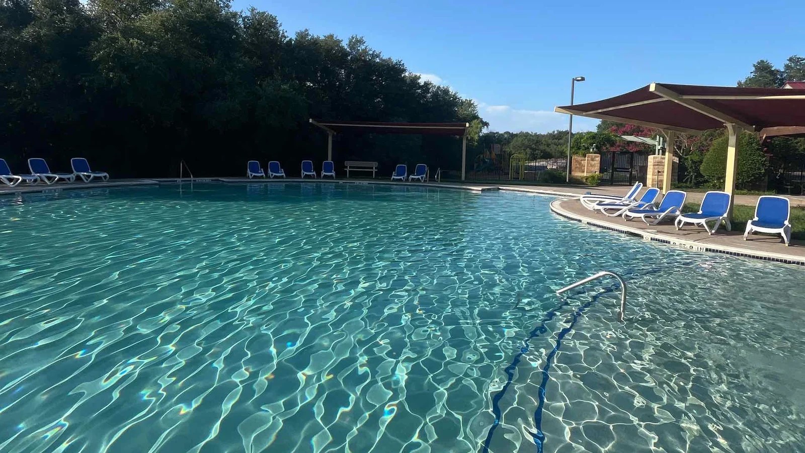 169 Marcheeta Way Leander, TX 78641 - Photo 35 of 39 The property features an expansive outdoor swimming pool with clear water, surrounded by lounge chairs