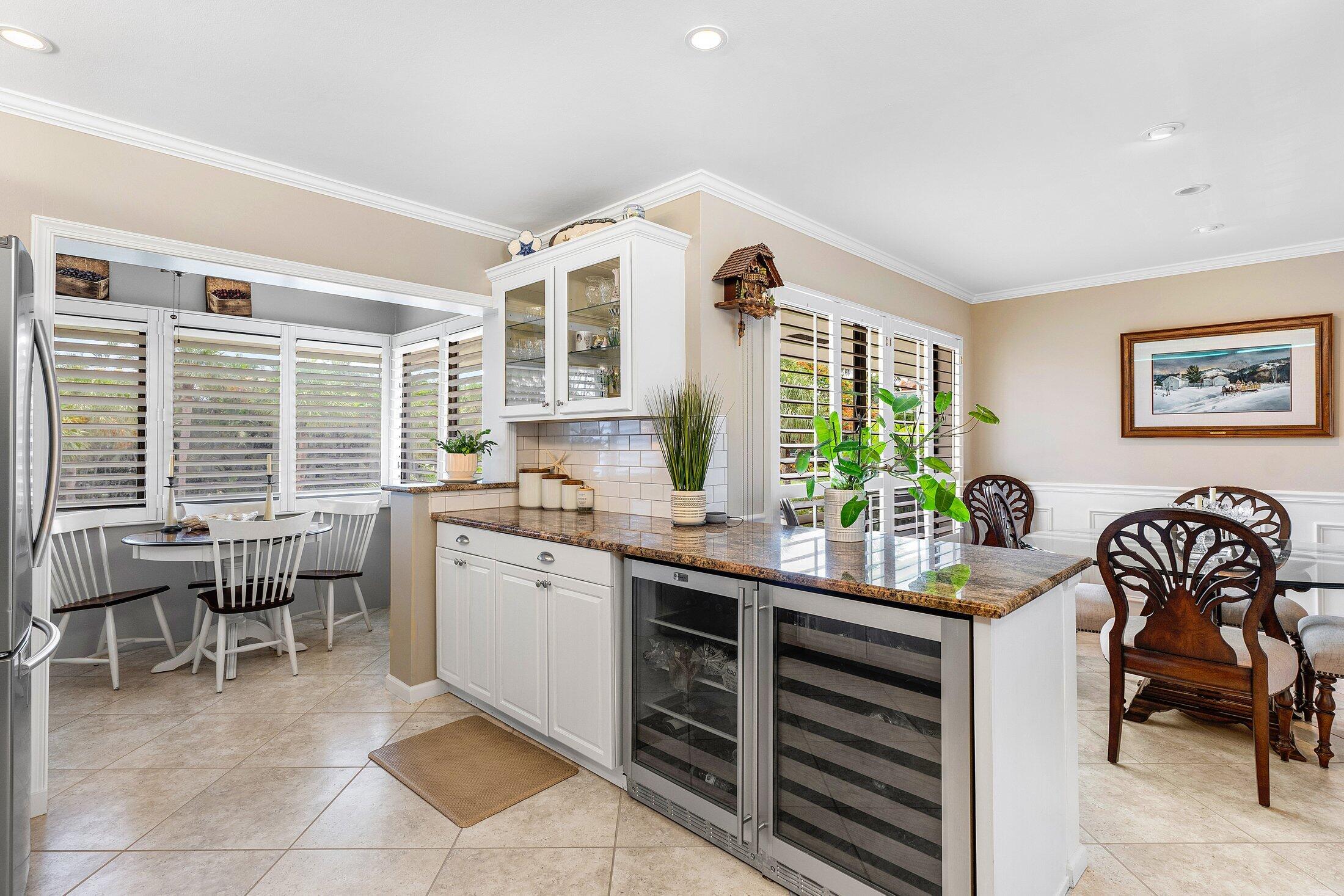 10093 Quail Covey Road, Unit HIBISCUS N Boynton Beach, FL 33436 - Photo 1 of 34 a kitchen with a table chairs and a stove