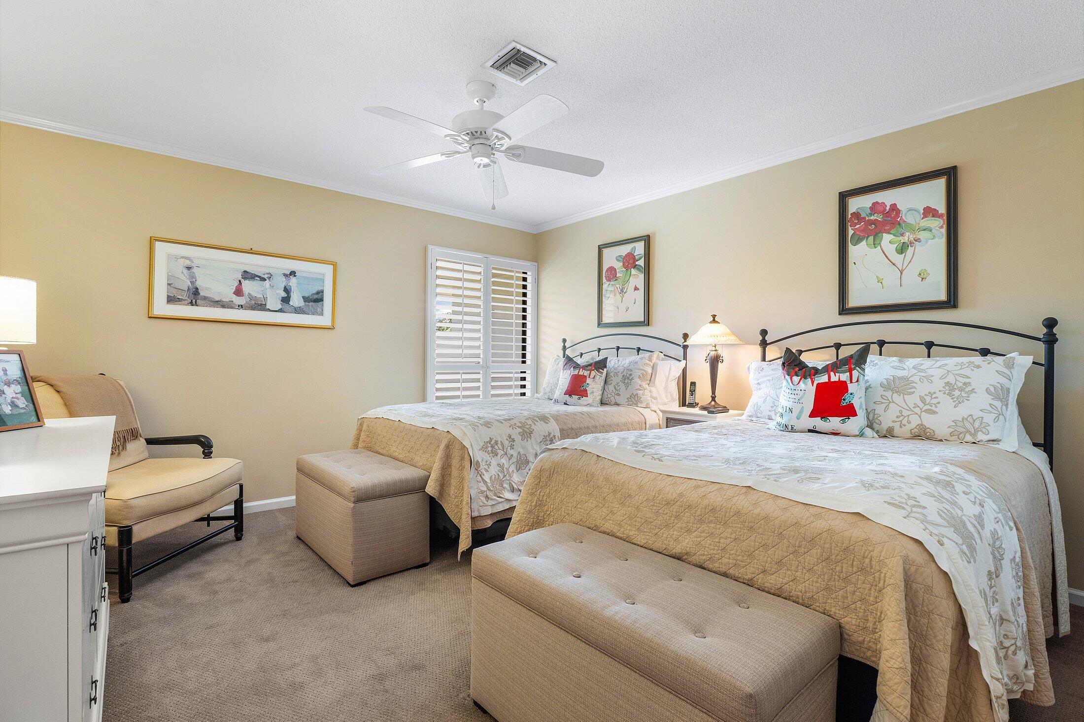 10093 Quail Covey Road, Unit HIBISCUS N Boynton Beach, FL 33436 - Photo 20 of 34 a spacious bedroom with a bed and a chandelier