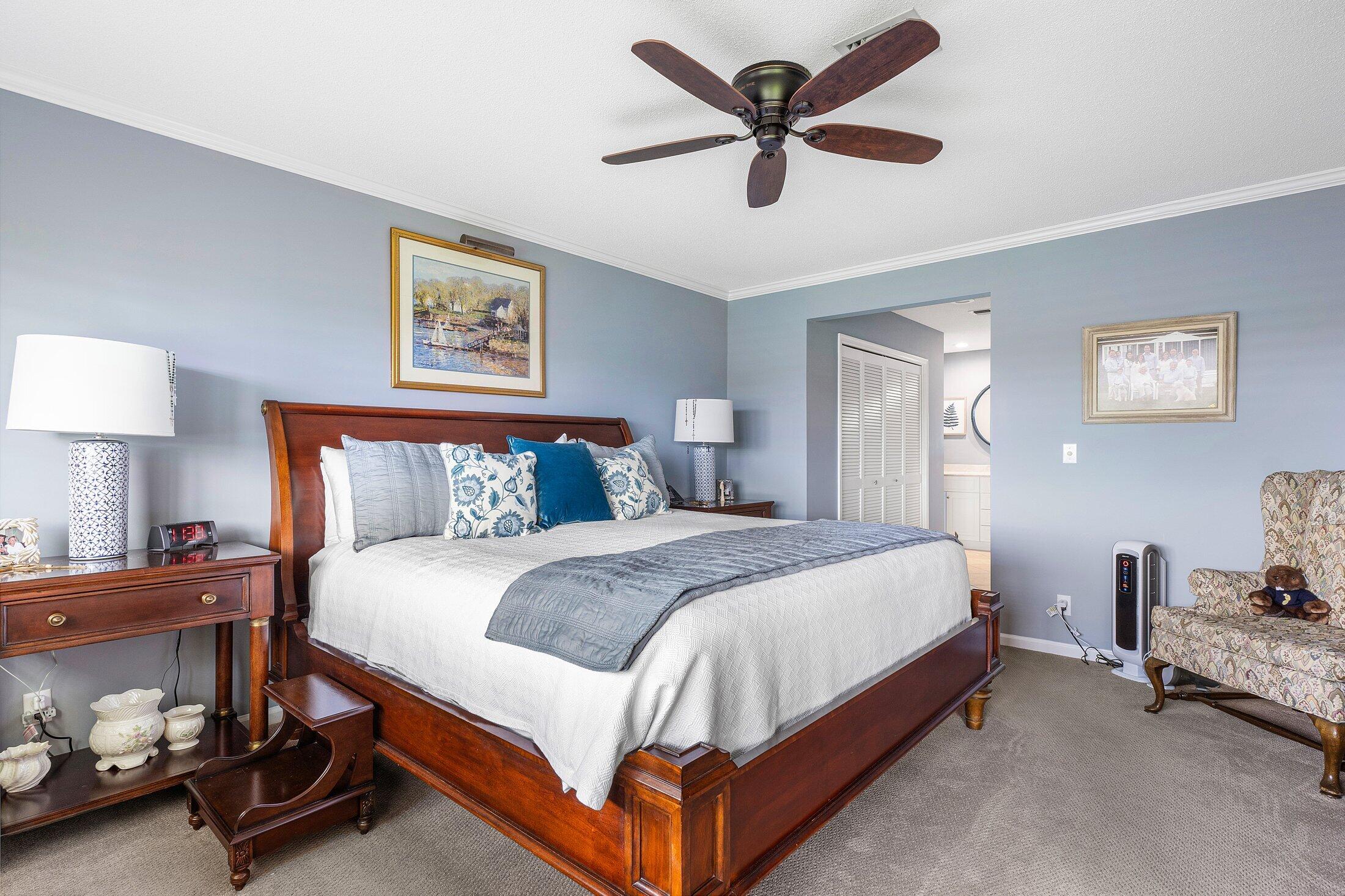 10093 Quail Covey Road, Unit HIBISCUS N Boynton Beach, FL 33436 - Photo 22 of 34 a bedroom with a bed and a chandelier