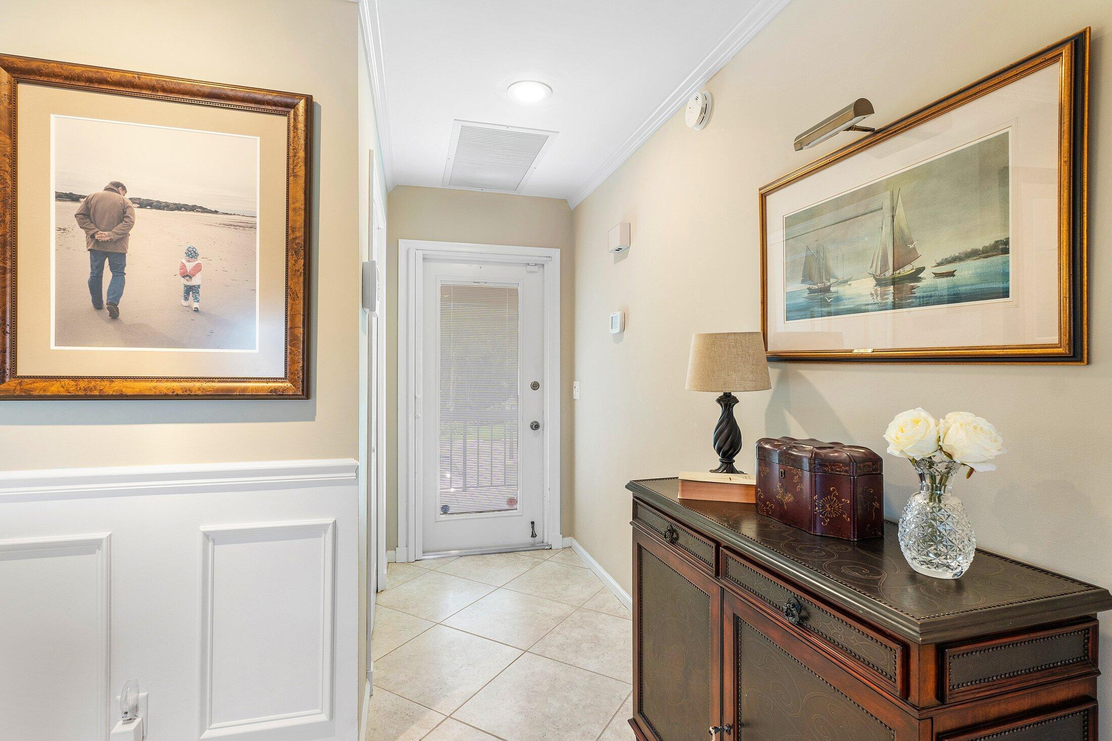 10093 Quail Covey Road, Unit HIBISCUS N Boynton Beach, FL 33436 - Photo 5 of 34 a hallway with painting and painting on the wall