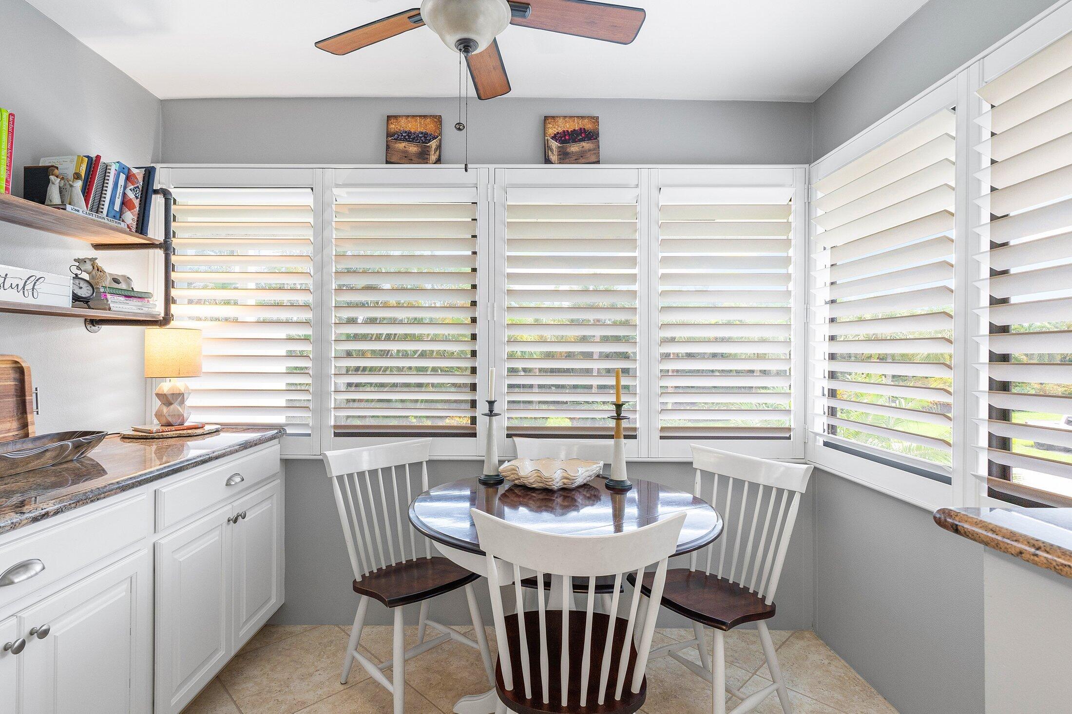 10093 Quail Covey Road, Unit HIBISCUS N Boynton Beach, FL 33436 - Photo 10 of 34 a view of a kitchen with a dining table and chairs