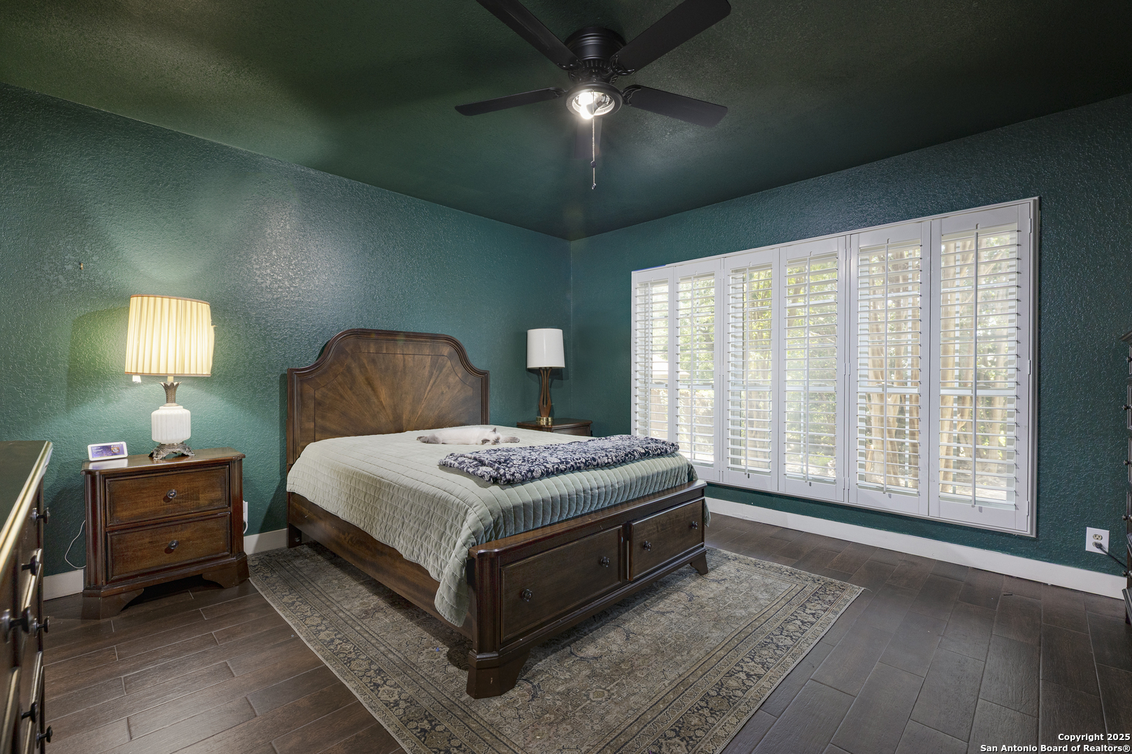 922 Hedgestone Drive San Antonio, TX 78258 - Photo 12 of 40 a bedroom with a bed lamps and a chandelier