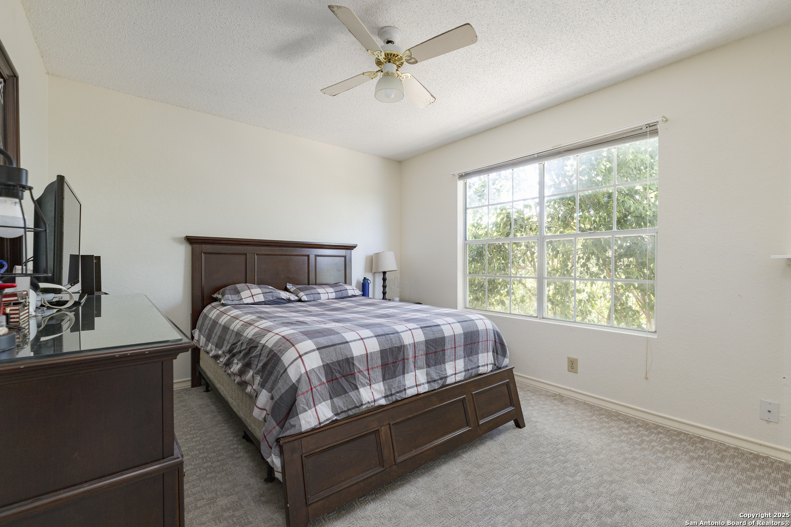 922 Hedgestone Drive San Antonio, TX 78258 - Photo 18 of 40 a bedroom with a bed a window and a flat screen television
