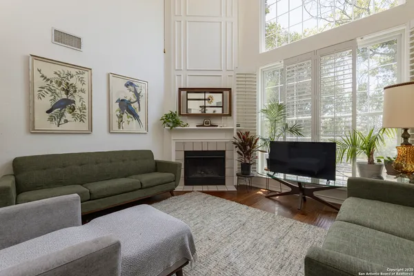 a living room with furniture a fireplace and a flat screen tv