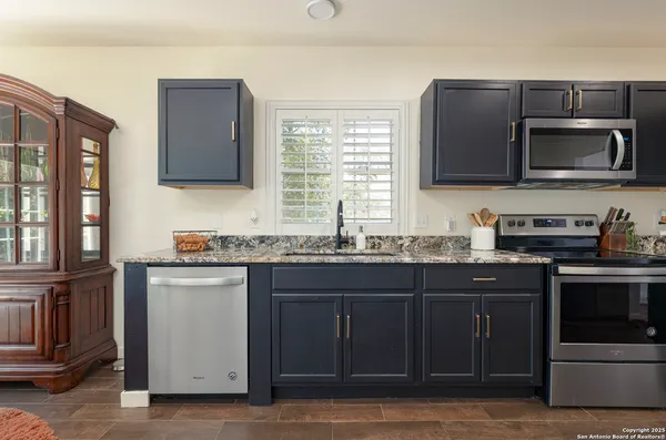 a kitchen with stainless steel appliances granite countertop a stove microwave and sink