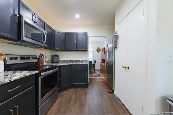 a kitchen with stainless steel appliances granite countertop a refrigerator a stove top oven a sink and dishwasher
