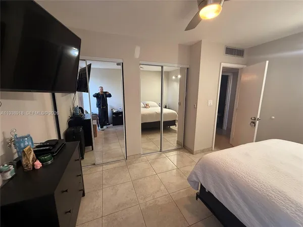 a bedroom with a bed and a view of living room