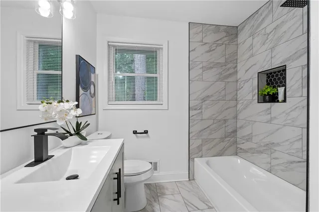 a bathroom with a sink a toilet and bathtub