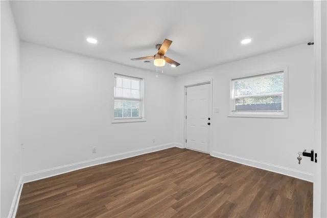 a view of a room with wooden floor and ceiling fan