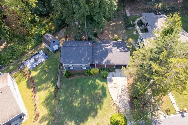 an aerial view of residential houses with outdoor space and trees