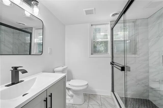 a bathroom with a sink a toilet and shower