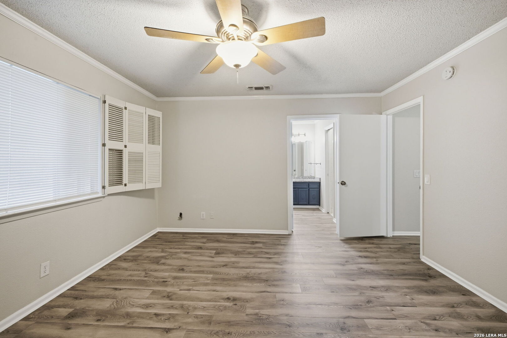 6106 Vance Jackson Road, Unit 15 San Antonio, TX 78230 - Photo 23 of 30 a view of an empty room with window and wooden floor