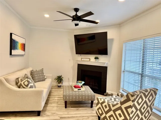 a living room with furniture a flat screen tv and a fireplace