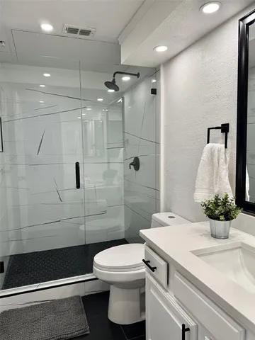 a bathroom with a sink a toilet and shower