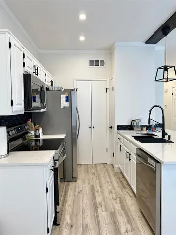 a kitchen with stainless steel appliances a sink stove refrigerator and cabinets