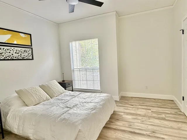a large bed sitting in a bedroom next to a window
