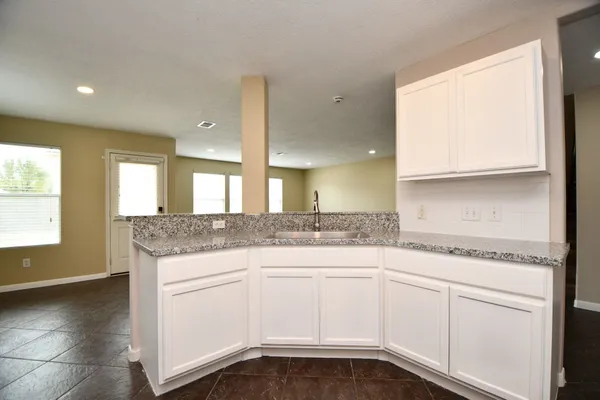 a kitchen with white cabinets and a sink
