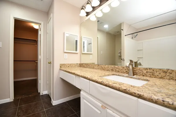 a bathroom with a granite countertop sink and a mirror