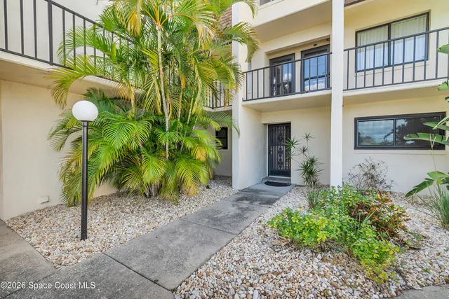 a view of a house with a plants and pathway