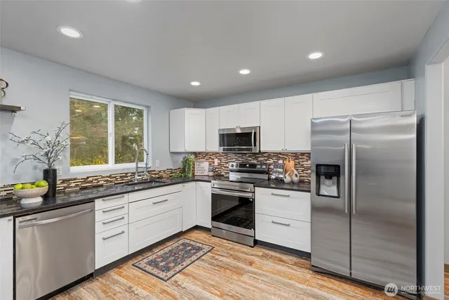 a kitchen with a sink stainless steel appliances and window
