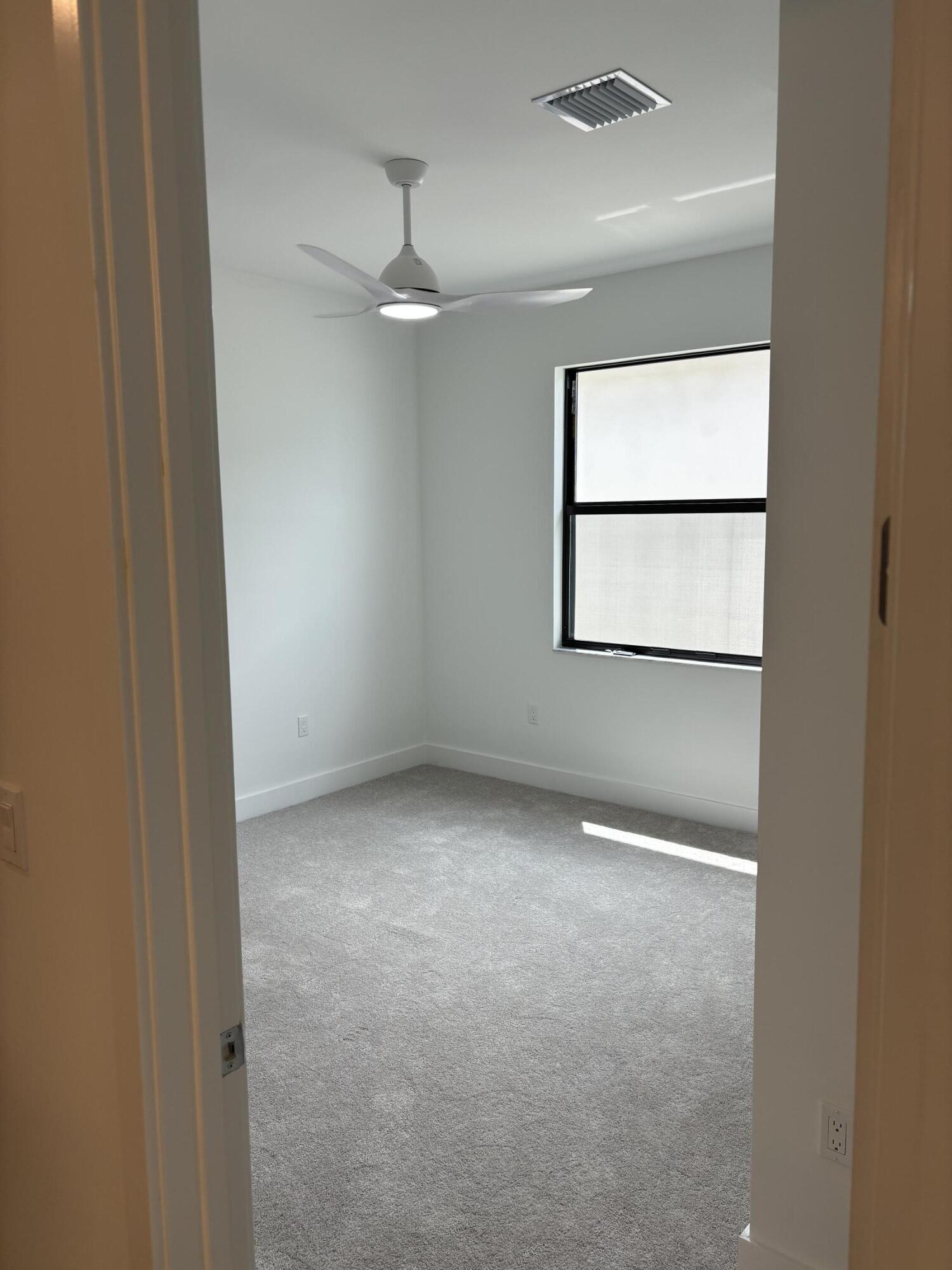 8617 Swinley Frst Way Boca Raton, FL 33434 - Photo 12 of 24 an empty room with a window and a fan