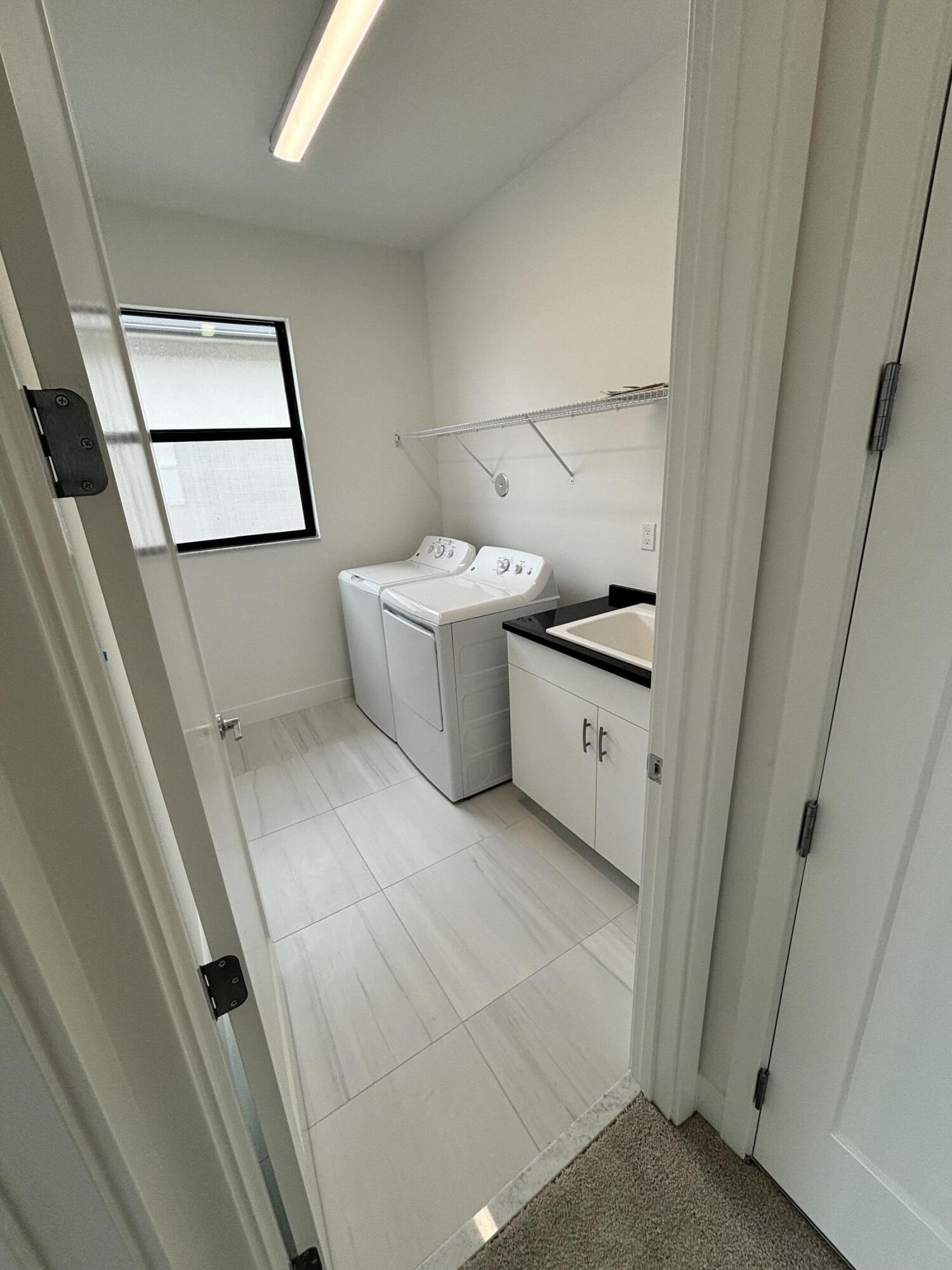 8617 Swinley Frst Way Boca Raton, FL 33434 - Photo 13 of 24 a kitchen with a wooden floor and washing machine