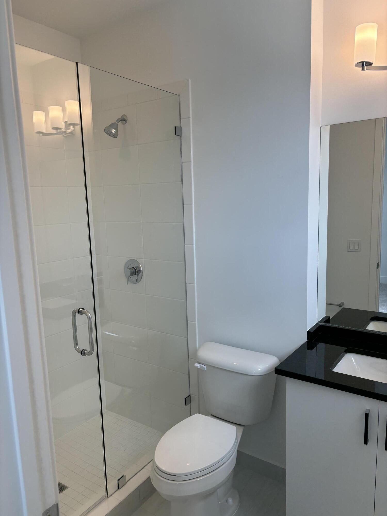 8617 Swinley Frst Way Boca Raton, FL 33434 - Photo 15 of 24 a bathroom with a granite countertop toilet a sink and shower