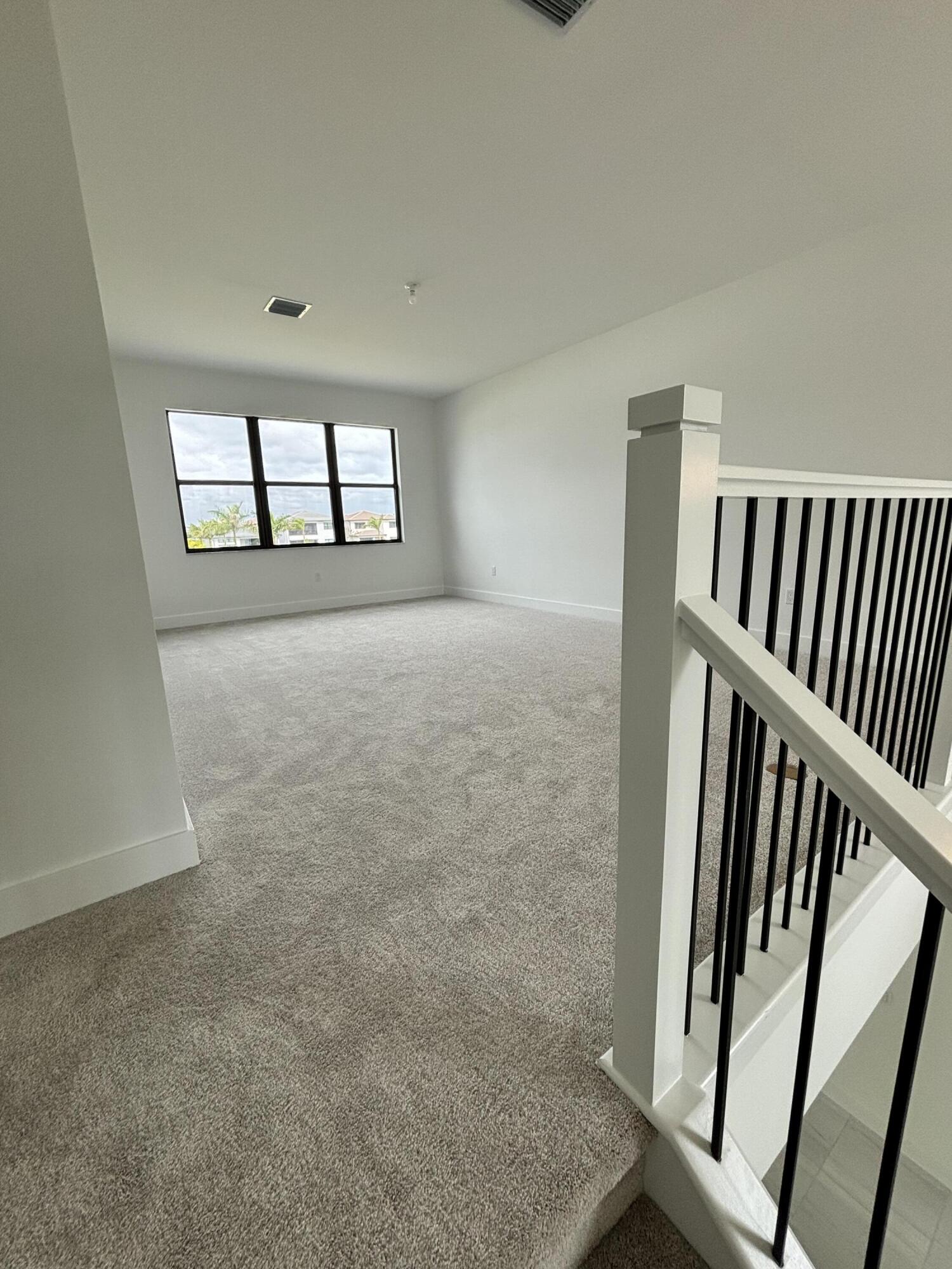 8617 Swinley Frst Way Boca Raton, FL 33434 - Photo 9 of 24 an empty room with windows & stairs