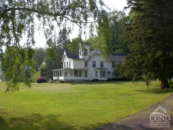 a front view of a house with yard and green space