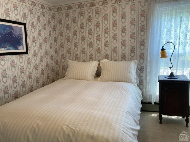 a bed sitting in a bedroom next to a window