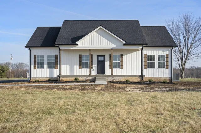 a view of an empty room with wooden floor and a ceiling fan