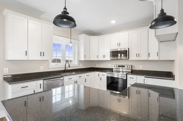 a view of an empty room with closet and wooden floor