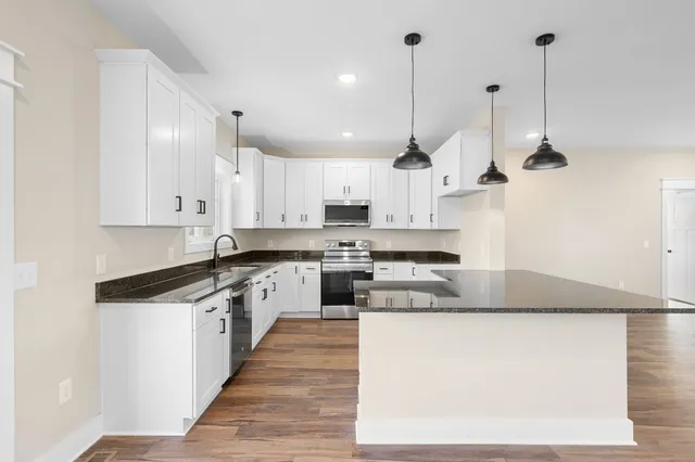 a bathroom with a bathtub shower sink vanity mirror and toilet
