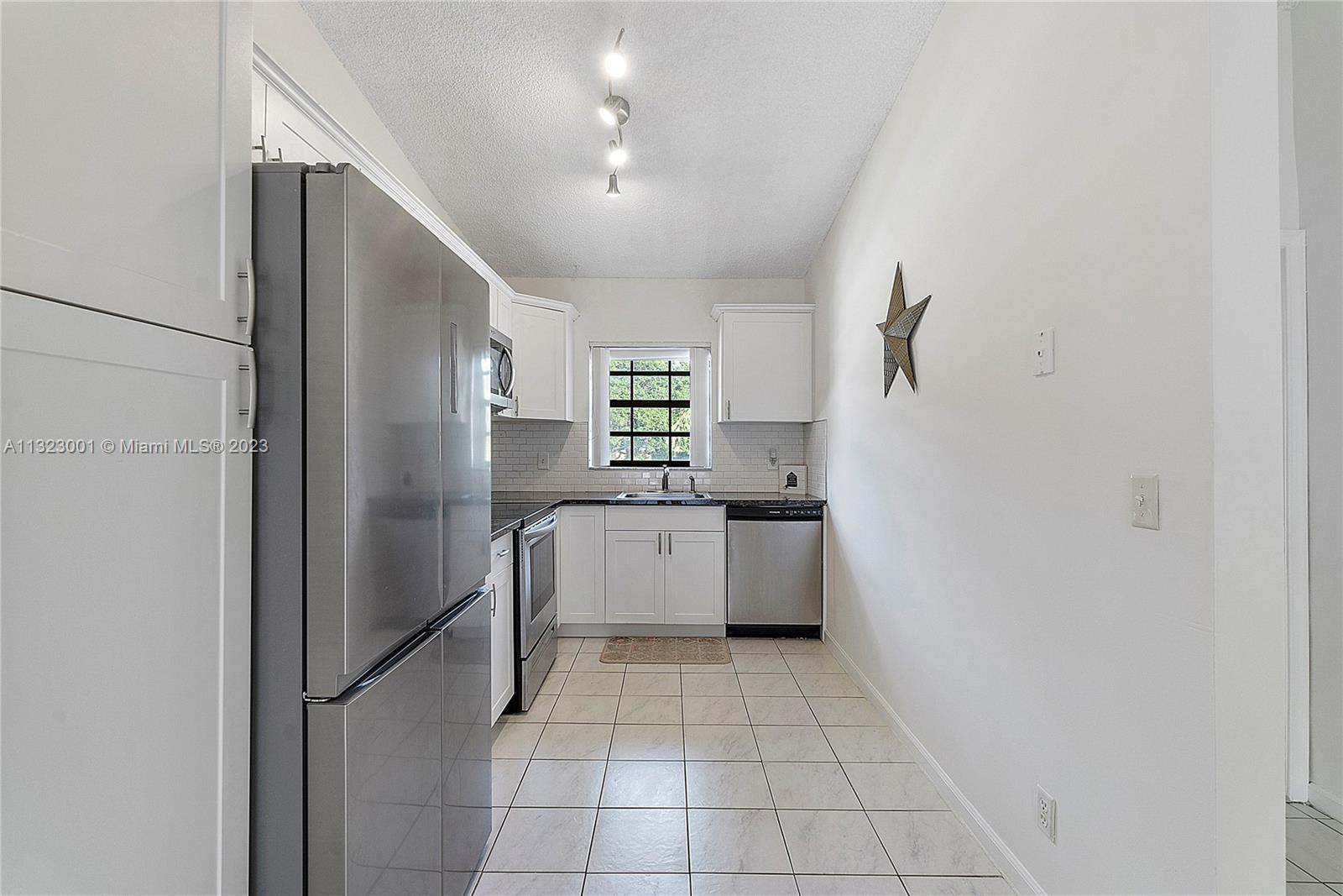3000 Norwood Place, Unit N202 Boca Raton, FL 33431 - Photo 14 of 26 a large white kitchen with a sink and refrigerator