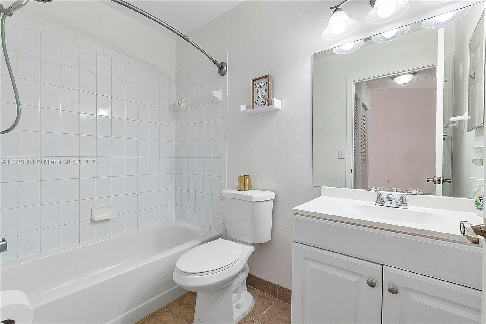 3000 Norwood Place, Unit N202 Boca Raton, FL 33431 - Photo 18 of 26 a bathroom with a sink a toilet and shower