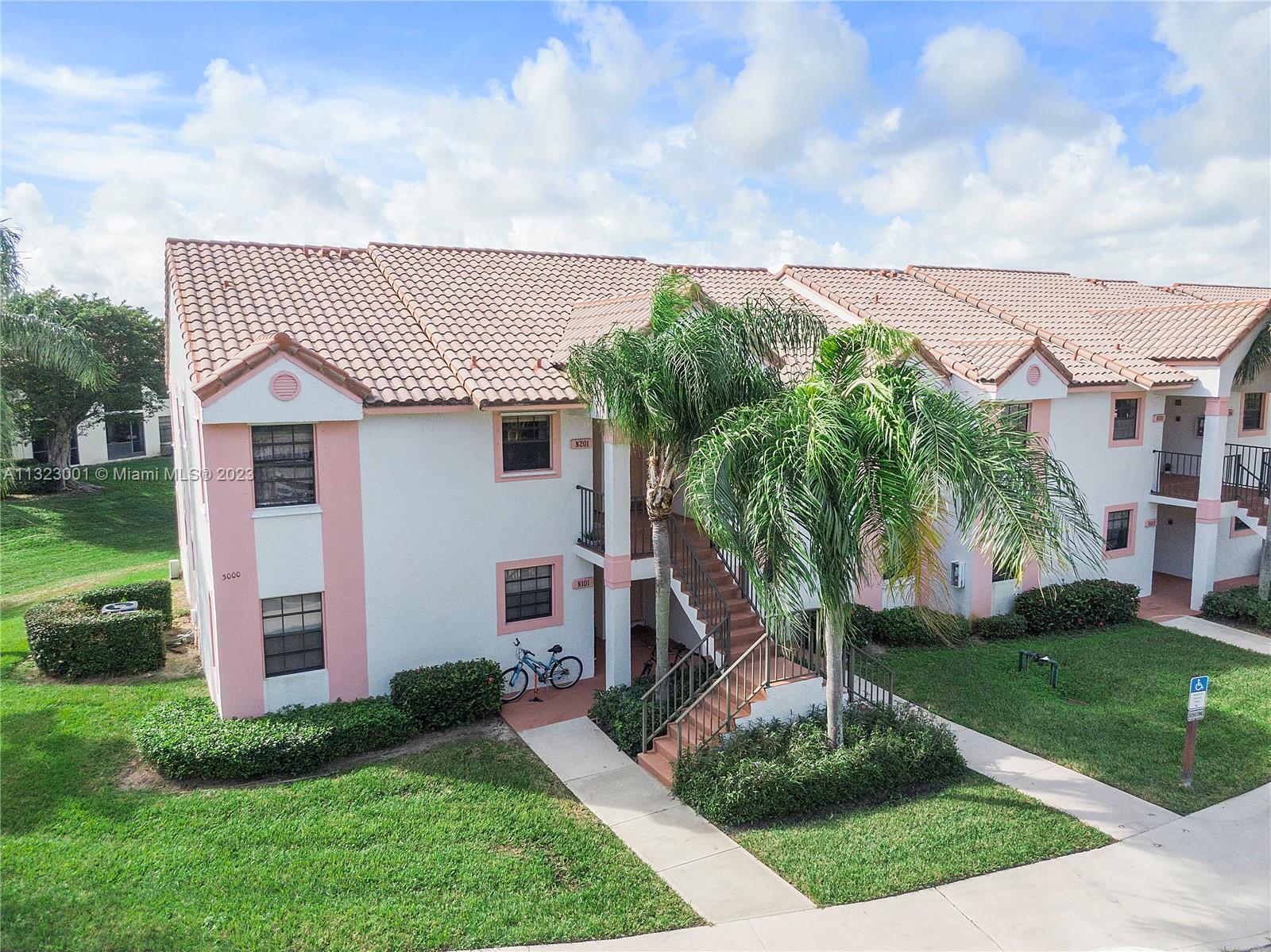 3000 Norwood Place, Unit N202 Boca Raton, FL 33431 - Photo 24 of 26 a front view of a house with a garden