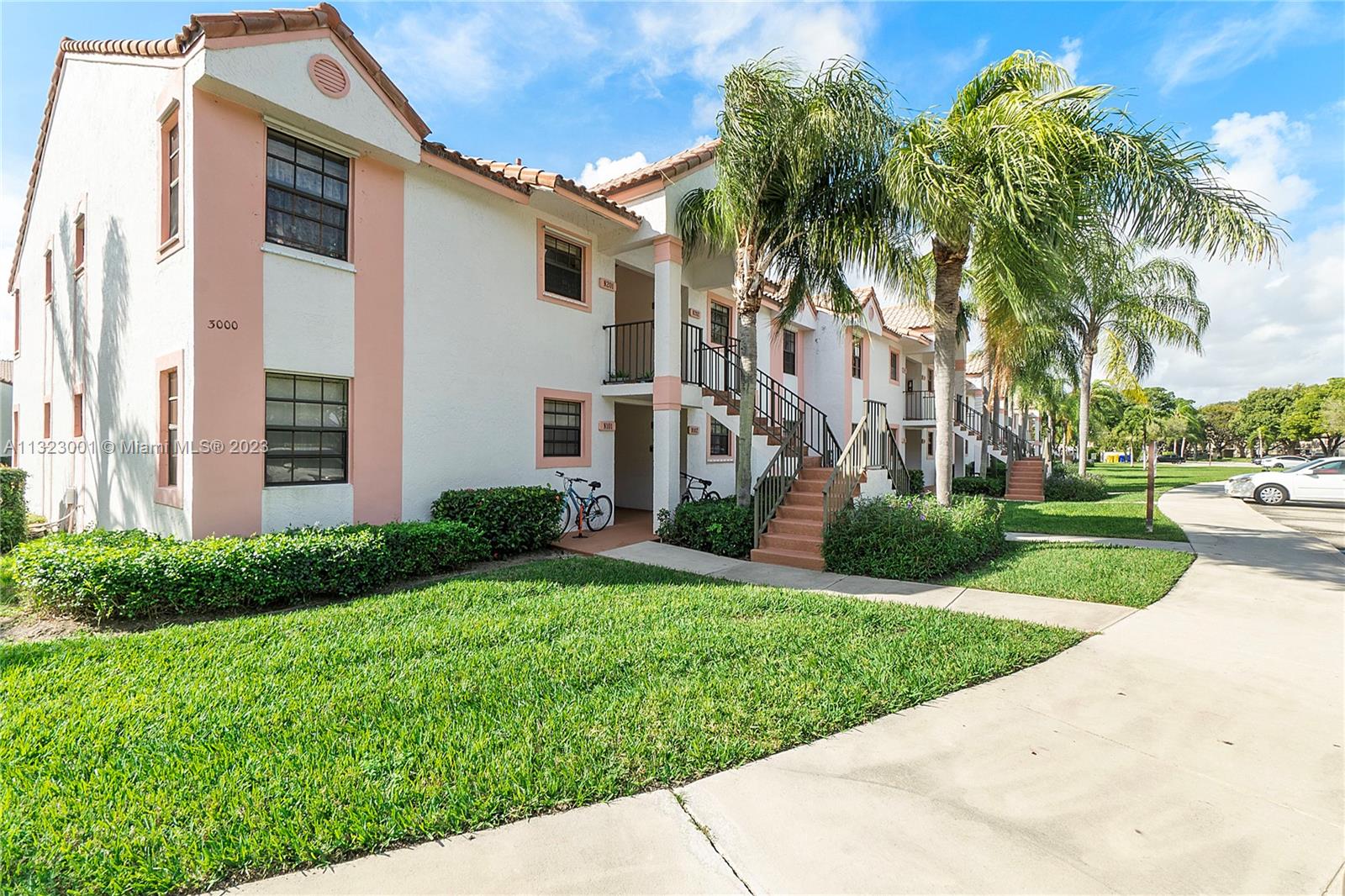 3000 Norwood Place, Unit N202 Boca Raton, FL 33431 - Photo 3 of 26 a view of a white house with a yard and palm trees
