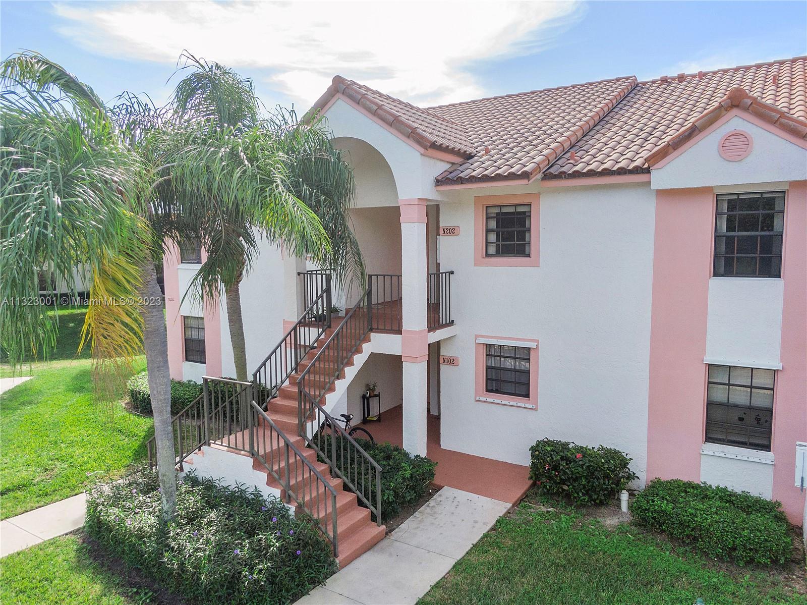 3000 Norwood Place, Unit N202 Boca Raton, FL 33431 - Photo 4 of 26 a front view of a house with garden