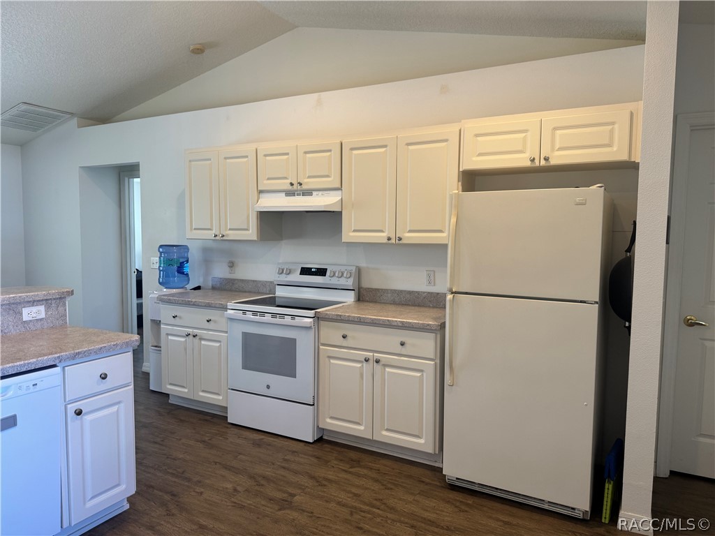 4588 East Van Ness Road Inverness, FL 34453 - Photo 2 of 34 a kitchen with white cabinets and white appliances