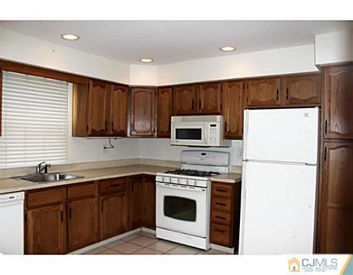 2204 Timber Oaks Road Edison, NJ 08820 - Photo 6 of 13 a kitchen with a sink a stove a refrigerator and cabinets