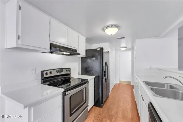 a kitchen with stainless steel appliances a stove a sink a refrigerator and cabinets