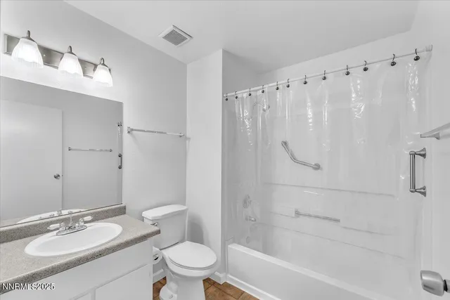a bathroom with a granite countertop sink a toilet and shower