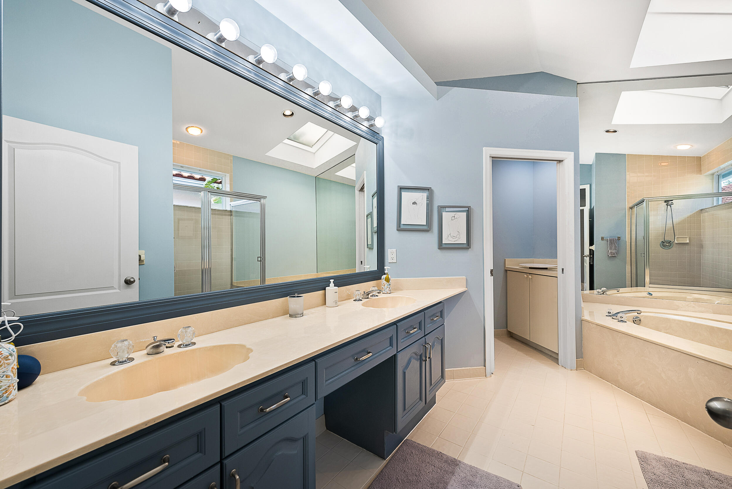 271 Eagleton Estates Boulevard Palm Beach Gardens, FL 33418 - Photo 16 of 37 a bathroom with a double vanity sink a large mirror and a bathtub