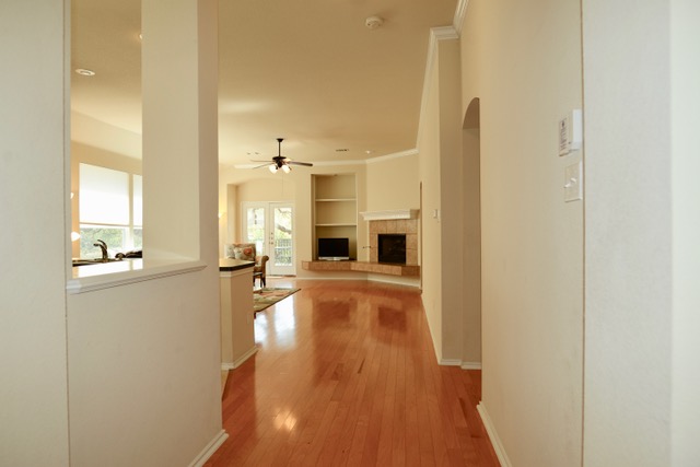 138 Chestnut Court Georgetown, TX 78633 - Photo 5 of 25 Rich hardwood floors guide you through this inviting hallway into a sun-kissed living area.