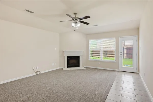 a view of an empty room with a fireplace and a window