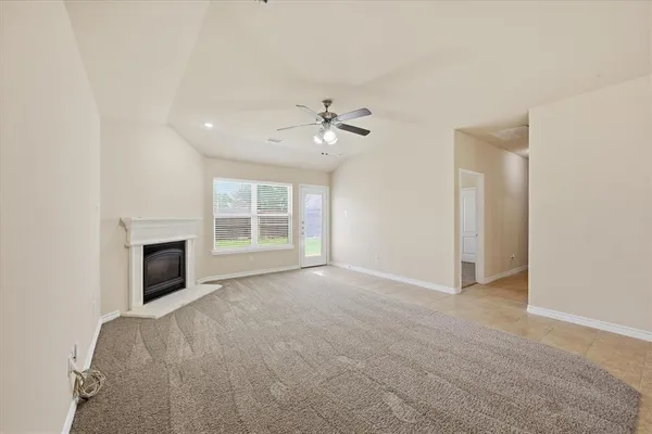 an empty room with fireplace and fan