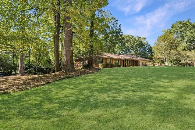 a view of a house with backyard and trees