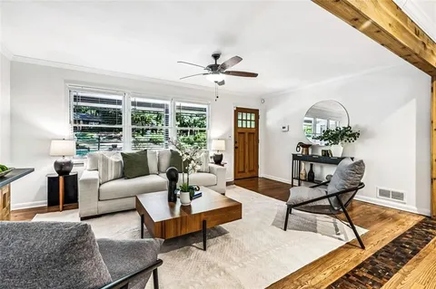 a living room with furniture and a ceiling fan