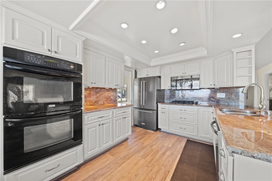 6607 New Ridge Drive Riverside, CA 92506 - Photo 11 of 46 a kitchen with granite countertop white cabinets and stainless steel appliances